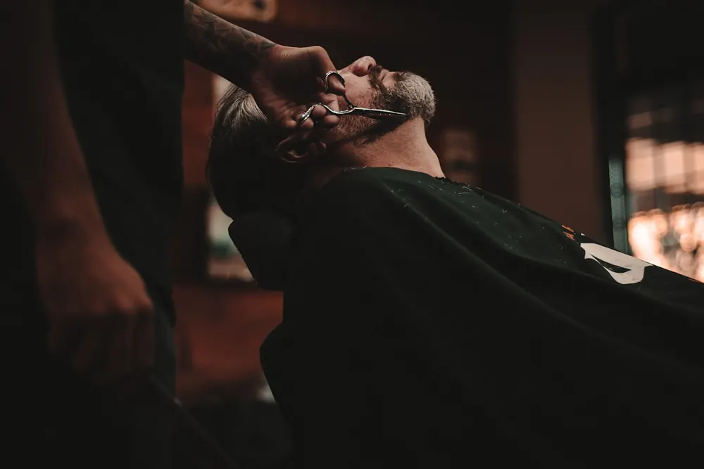 A barber working a fade under warm shop light